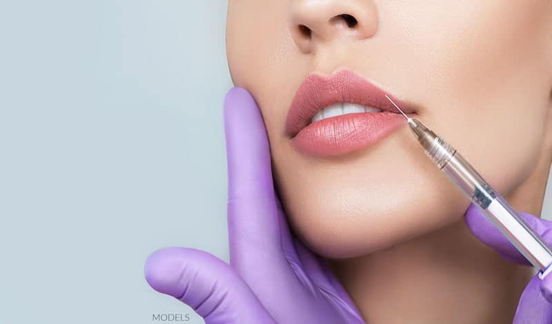 Woman getting cosmetic injection in her lip.