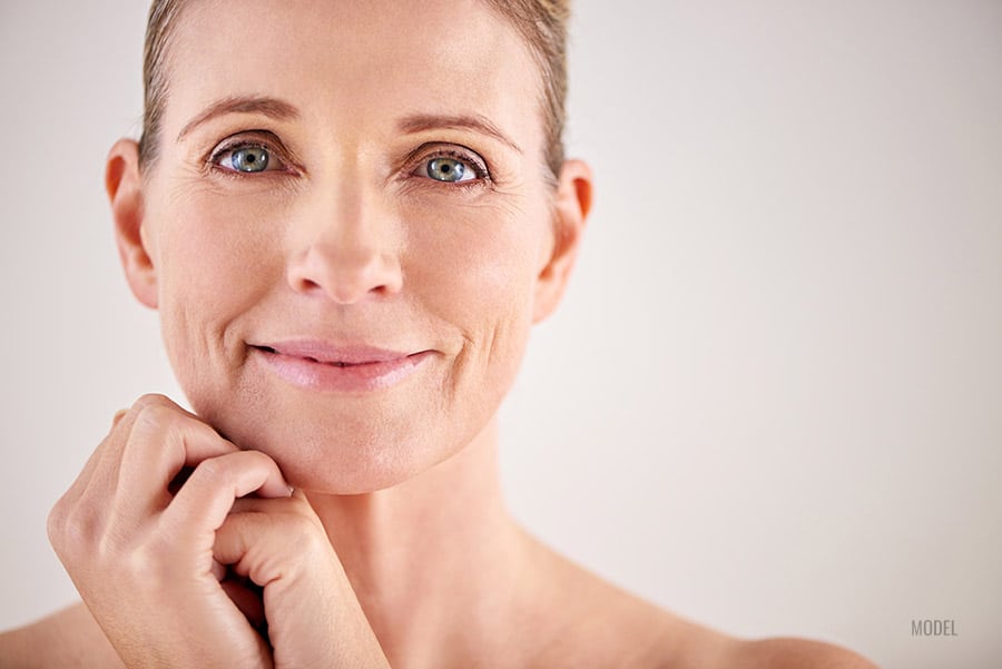 A mature woman with beautiful eyes poses for the camera.